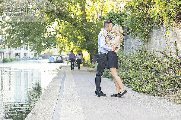 Freund und Freundin küssen sich  während sie an der Promenade stehen