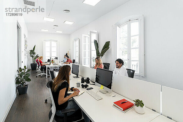 Männliche und weibliche Fachkräfte arbeiten in einem modernen Büro zusammen
