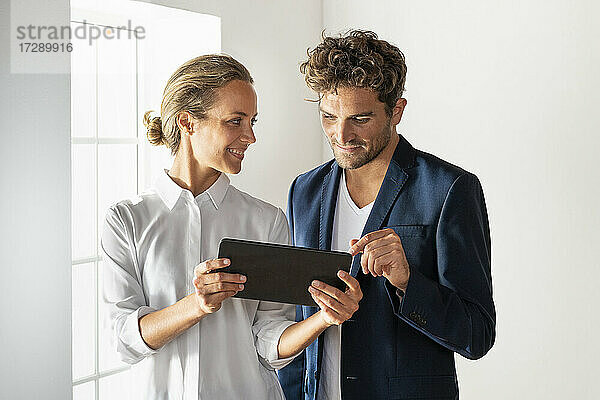 Geschäftsfrau zeigt digitales Tablet  während sie im Büro steht