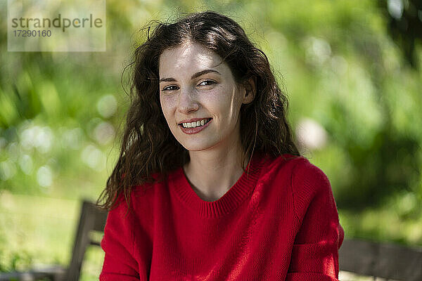 Lächelnde schöne junge Frau im Garten