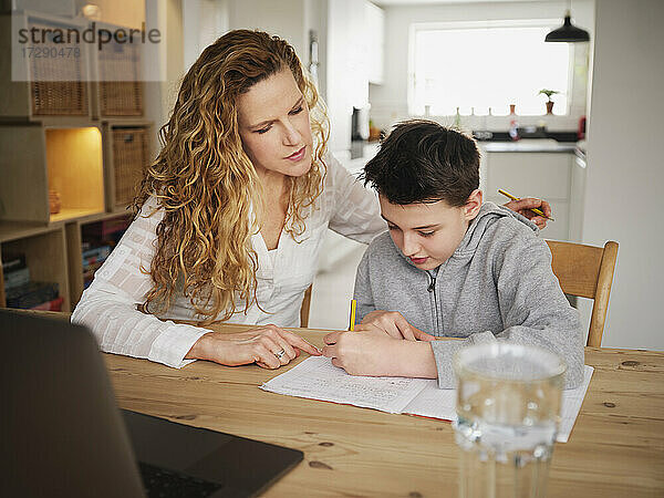 Mutter unterrichtet  während Sohn zu Hause schreibt