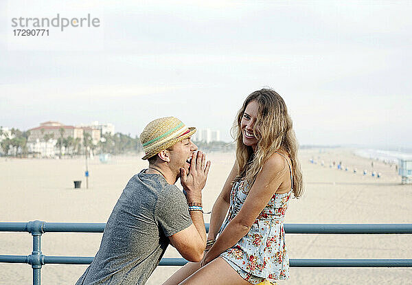 Glückliche Frau mit Freund im Urlaub am Strand von Santa Monica