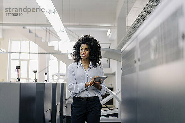 Geschäftsfrau mit digitalem Tablet bei der Arbeit in der Industrie