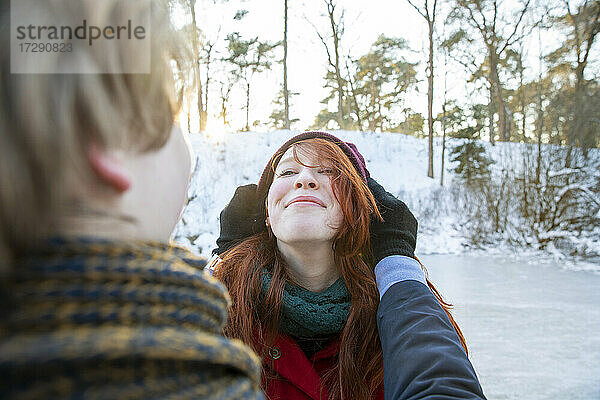 Lächelnde Freundin genießt das Wochenende mit ihrem Freund im Winter