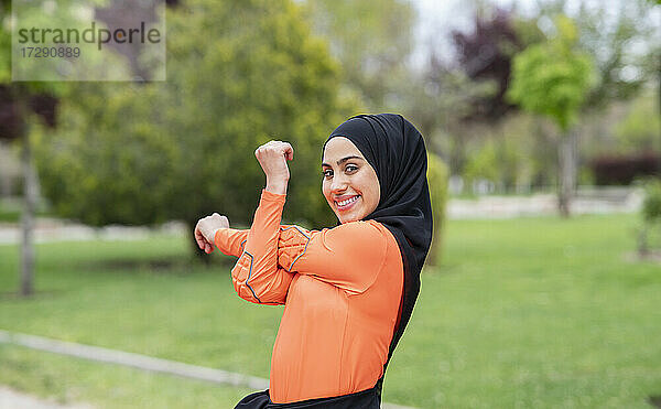 Lächelnde arabische Frau streckt sich im öffentlichen Park