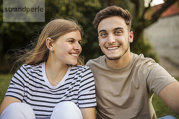 Glückliches Paar sitzt zusammen in einem öffentlichen Park