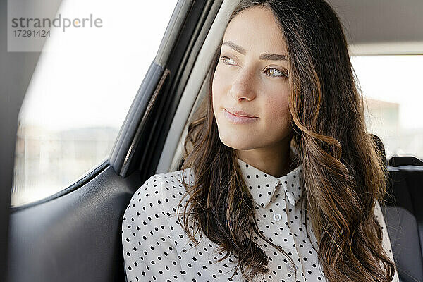 Schöne Geschäftsfrau schaut weg  während sie im Auto sitzt
