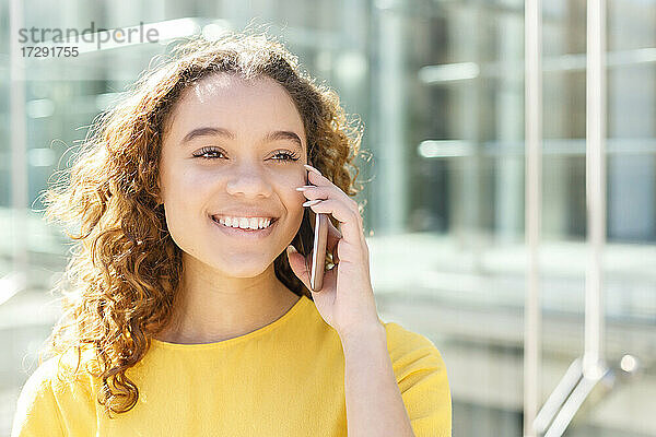 Junge schöne Frau spricht mit einem Smartphone