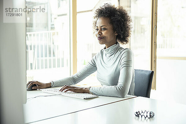 Afro-Geschäftsfrau mit Computer im Büro