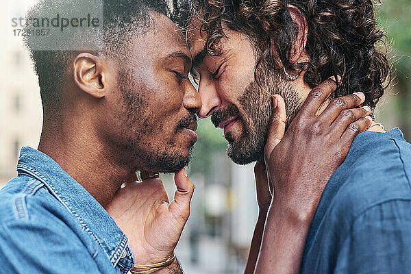 Homosexuelles Paar mit geschlossenen Augen bei einer Romanze