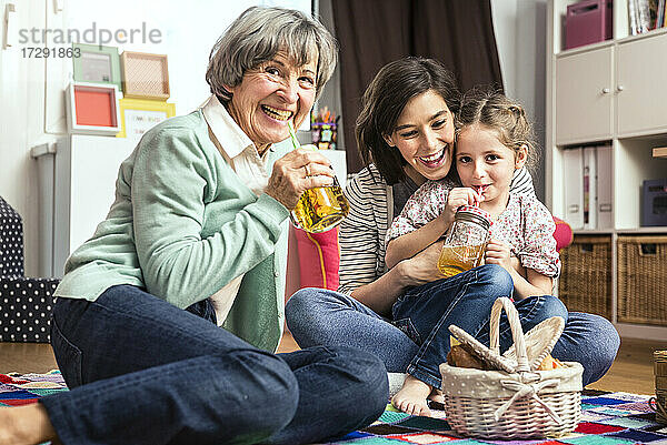 Mehrgenerationenfamilie beim Picknick im Kinderzimmer