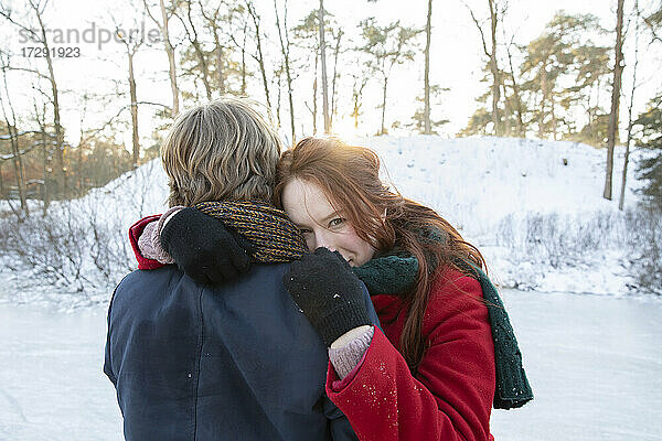 Freund umarmt Freundin im Winter