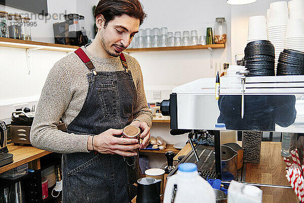 Männlicher Besitzer bereitet Kaffee im Geschäft zu