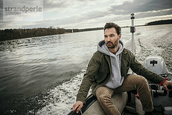 Hübscher Mann sitzt in einem Boot am Seddinsee