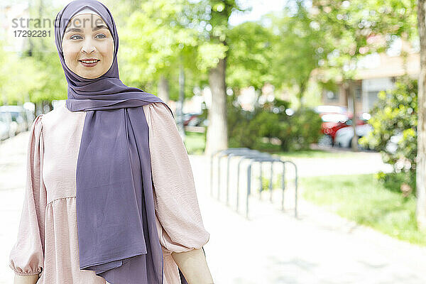 Junge Frau mit Hidschab  die im Park steht und wegschaut