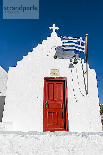 Weiß getünchte Kirche mit griechischer Flagge in Mykonos  Griechenland