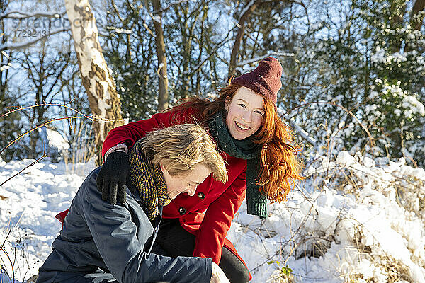 Lächelndes Paar  das sich im Schnee vergnügt