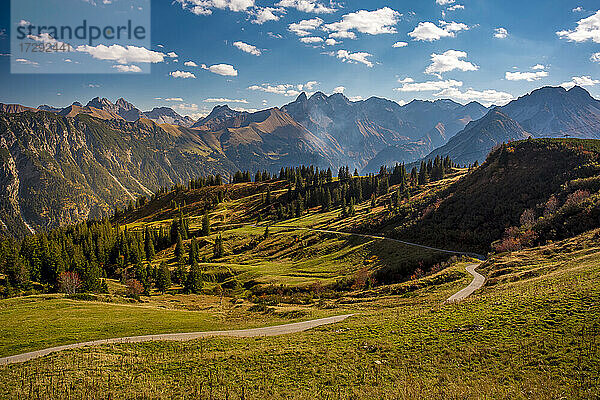 Malerische Aussicht auf eine kurvenreiche Straße in den Allgäuer Alpen im Herbst