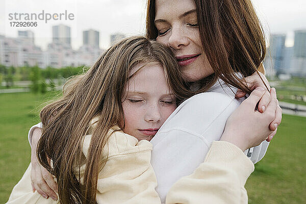 Tochter umarmt Mutter im Park