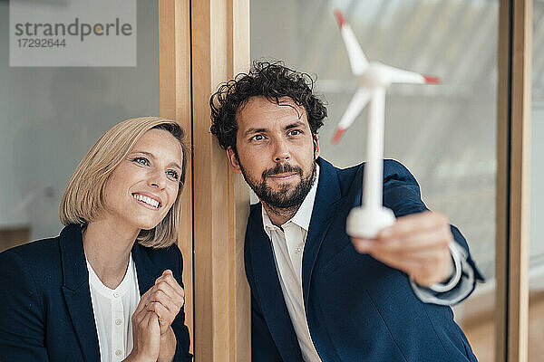 Professionelles Team betrachtet das Modell einer Windkraftanlage im Büro
