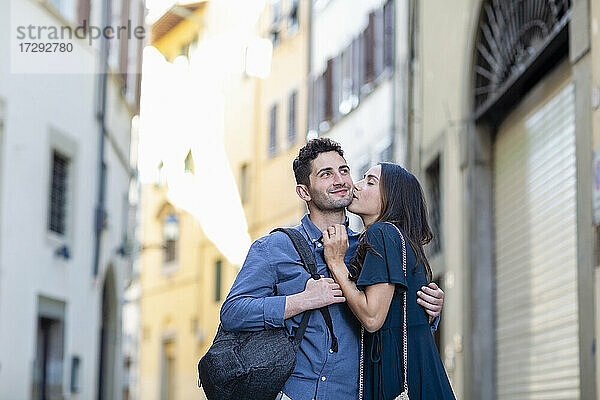 Weibliche Touristin küsst Mann auf der Straße in der Stadt