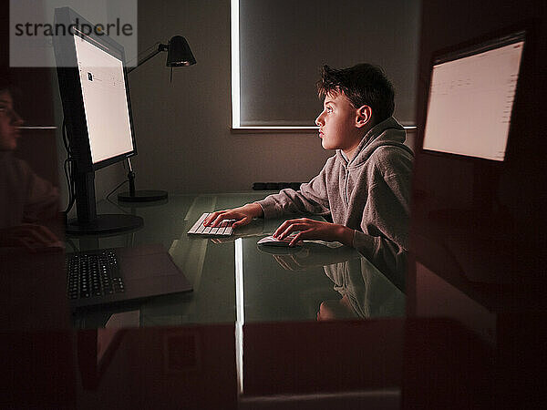 Junge benutzt Computer beim Lernen zu Hause