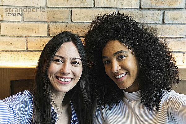 Lächelnde Freundinnen machen ein Selfie an der Bar