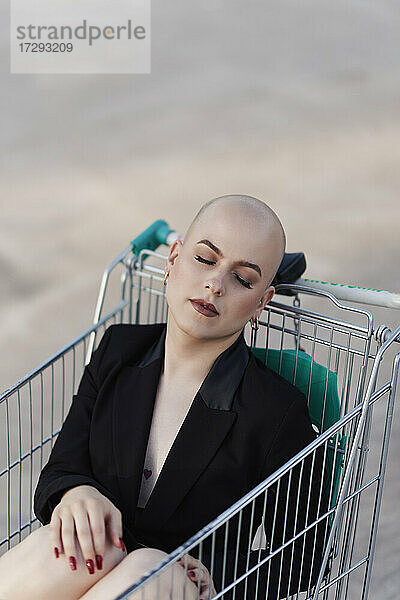 Glatzköpfige Transgender-Frau schläft im Einkaufswagen