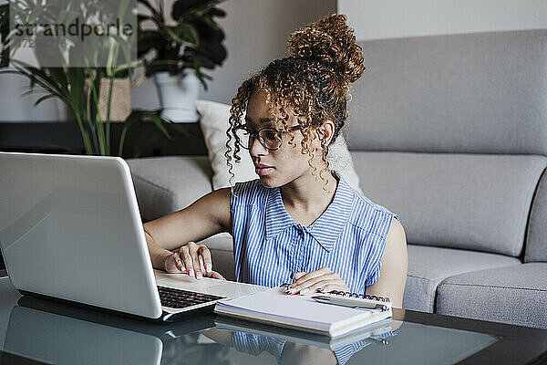 Geschäftsfrau mit Brille arbeitet zu Hause am Laptop