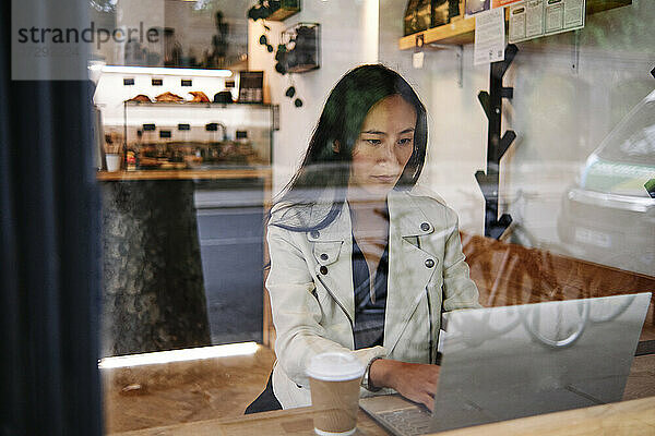 Frau benutzt Laptop in einem Kaffeehaus