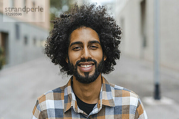 Junger Mann mit Afrofrisur lächelnd