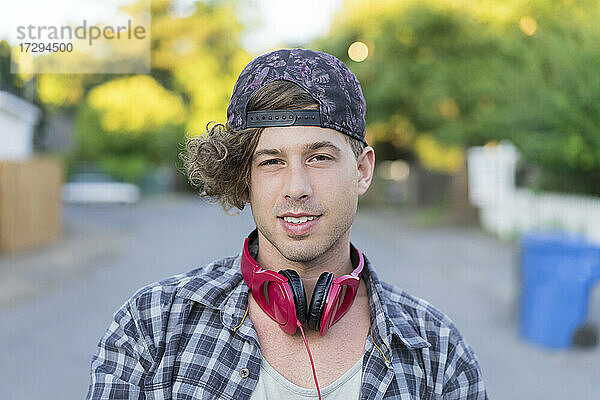 Junger Mann mit Kopfhörern auf der Straße