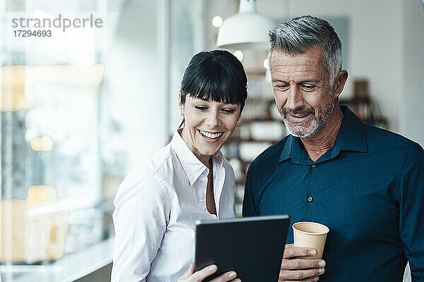 Weibliche und männliche Besitzer nutzen ein digitales Tablet in einem Coffee Shop