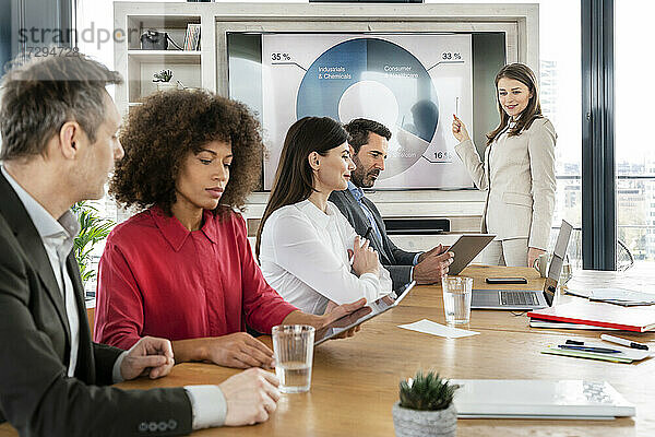 Geschäftsfrau schaut auf männliche und weibliche Kollegen  die im Büro an Grafiktabletts arbeiten