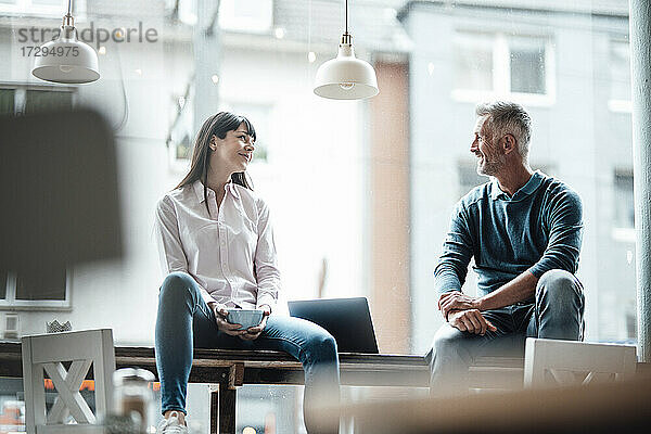 Weibliche und männliche Unternehmer lächelnd in einem Café sitzend