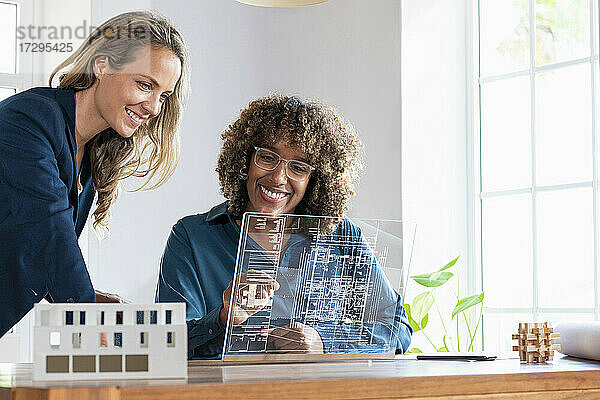 Mid adult businesswomen planning strategy on futuristic digital tablet at office