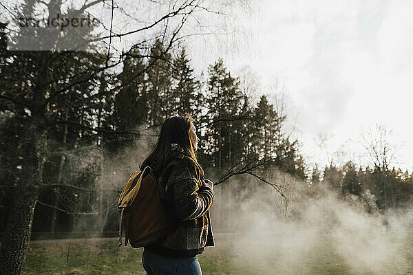 Junge Forscherin mit Rucksack wandern im Wald