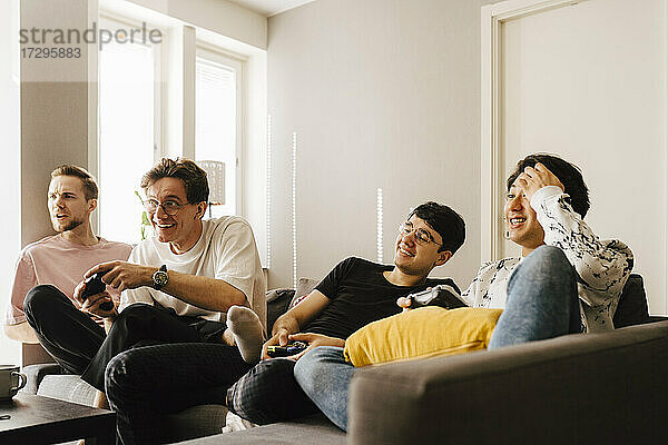 Junge männliche Freunde spielen Videospiel im Wohnzimmer