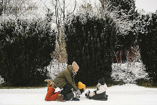Playful lesbische Mütter genießen mit Tochter auf Schnee im Winter