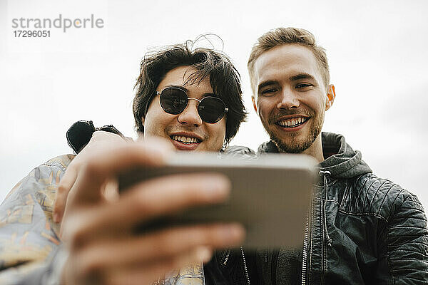 Glückliche multiethnische männliche Freunde nehmen Selfie auf Handy