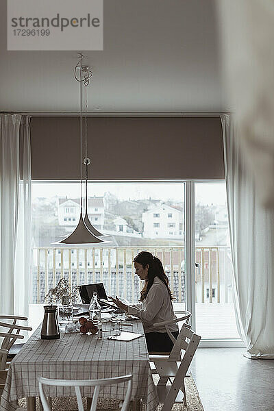 Geschäftsfrau arbeitet am Laptop im Büro zu Hause