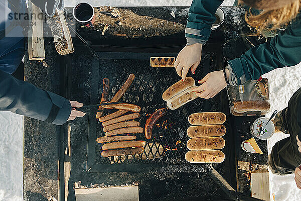 Direkt über der Aufnahme von Freunden  die Würstchen auf dem Grill zubereiten