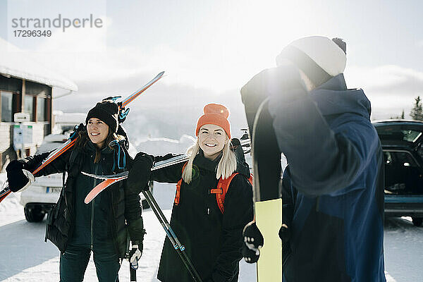 Lächelnde Freunde stehen im Skigebiet im Winter