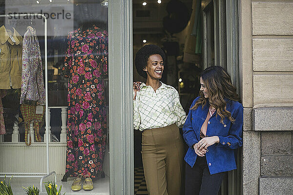 Weibliche Unternehmer lachen  während sie in einem Bekleidungsgeschäft miteinander reden