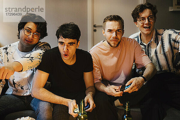 Junge männliche Freunde spielen Videospiel zu Hause
