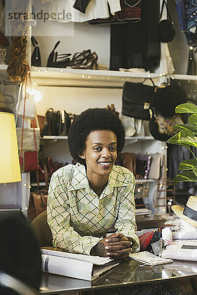 Afrikanische Mitarbeiterin lehnt sich im Laden an einen Tisch