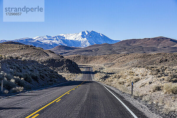 USA  Kalifornien  Bishop  Highway 6 durch Wüstenlandschaft mit schneebedeckten Sierra Nevada Mountains in der Ferne