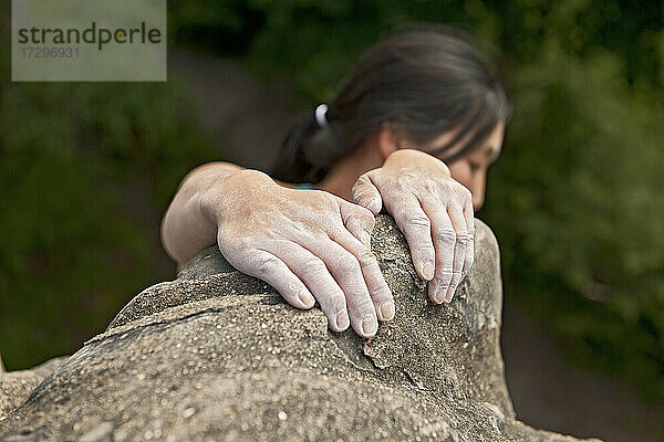 Frau klettert auf den Sandsteinfelsen am Harrison's Rock in England