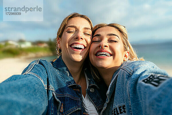Zwei schöne lächelnde Freundinnen machen ein Selfie