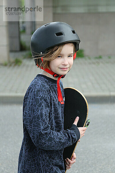 Porträt eines Mädchens mit einem Skateboard.